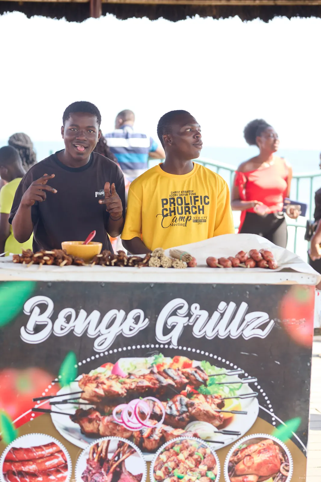 Two vendors smiling behind a Bongo Grillz food stall