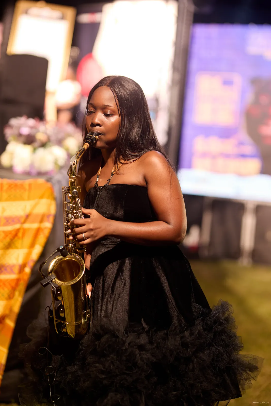 Saxophonist in a black strapless tulle dress performing at night