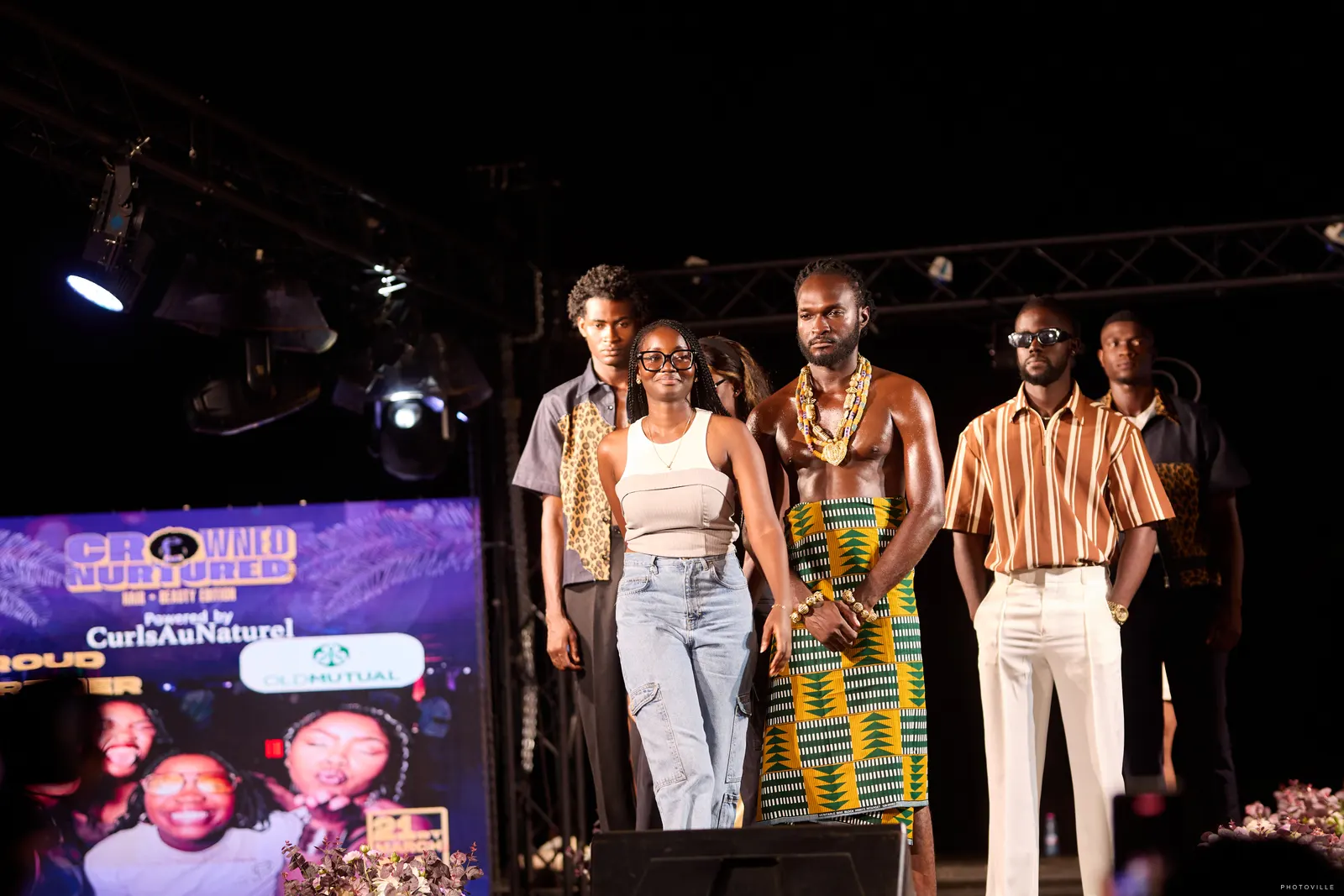 Menswear models in kente and striped looks lined up for the finale
